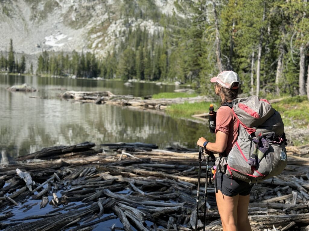 Ein kristallklarer Bergsee, umgeben von grünen Wiesen und gewaltigen Gipfeln