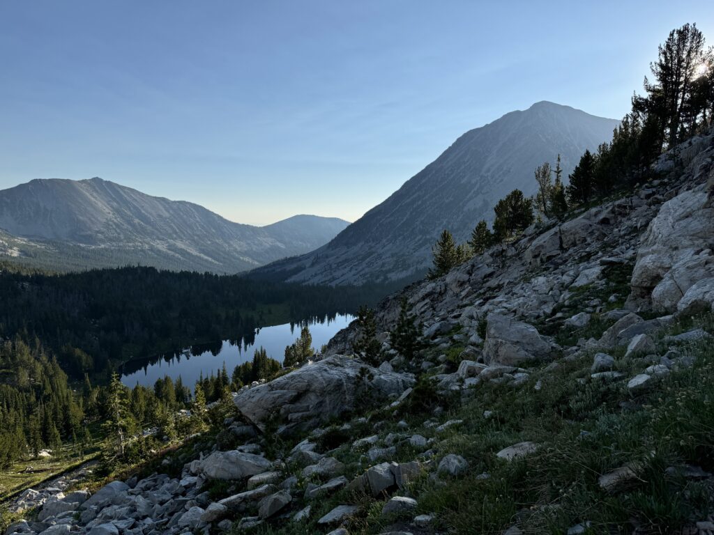 Die schimmernde Oberfläche eines Sees spiegelt den blauen Himmel wider. Der perfekte Ort, um einen Moment der Ruhe zu genießen, trotz der ständig lauernden Mücken.