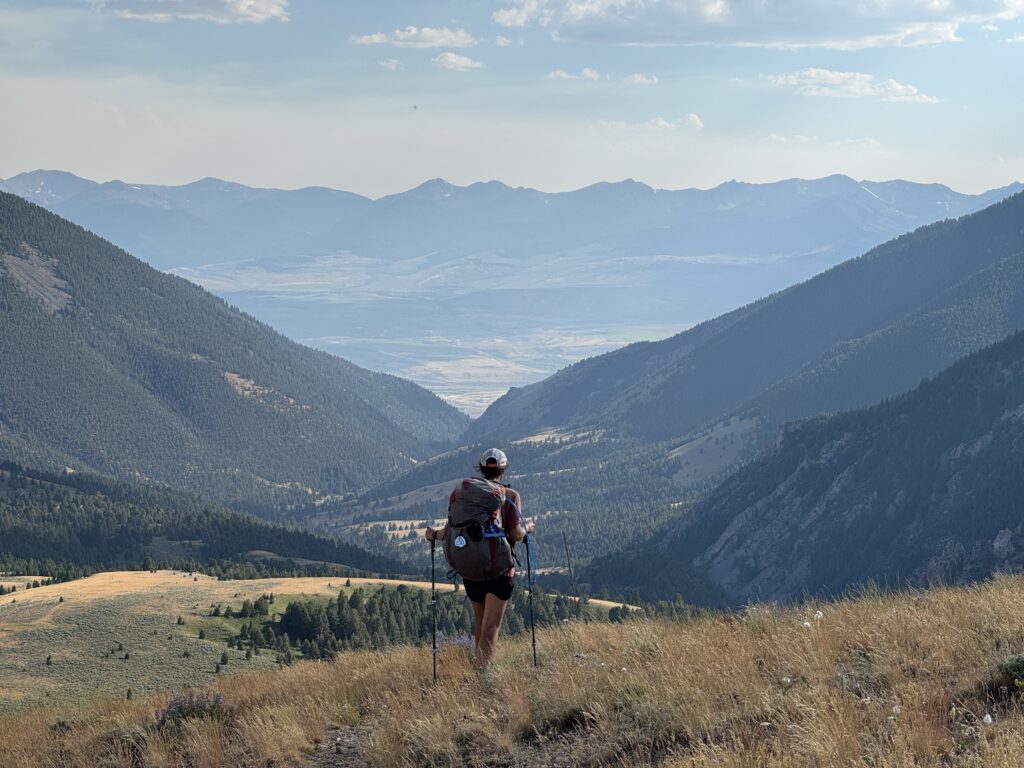 Der Trail schlängelt sich entlang eines Gratkammes, der einen weiten Blick auf die umliegenden Täler und Seen bietet.